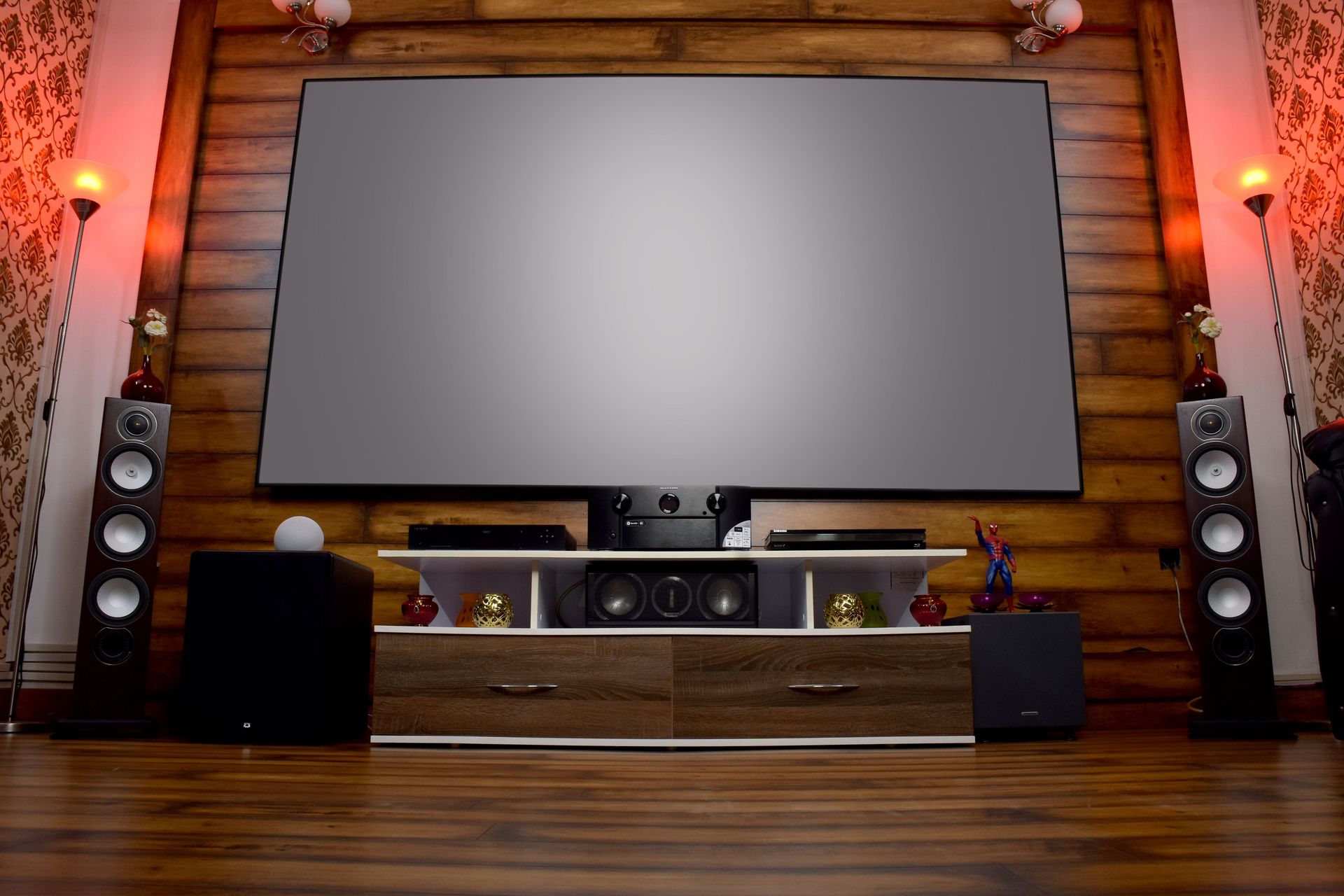Stylish home theater featuring large screen, audio system, and decor, perfect for entertainment.